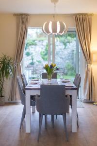 uma sala de jantar com uma mesa branca e cadeiras em Delightful cottage just steps from Kenmare town em Kenmare