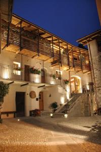 un edificio blanco con escaleras y balcones por la noche en Ostello del Castello Tirano, en Tirano