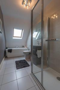 uma casa de banho com um chuveiro, uma banheira e um lavatório. em Delightful cottage just steps from Kenmare town em Kenmare