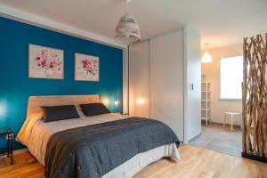 a bedroom with a bed and a blue wall at Ty Melen Glaz - 200m de la plage in Bénodet