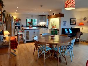 a kitchen and dining room with a wooden table and chairs at Stone fronted detached cottage just over 2 miles from Mulranny village in Mulranny