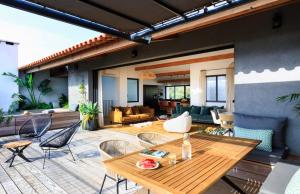 a patio with a wooden table and chairs at Penthouse Les Oliviers in Porto-Vecchio