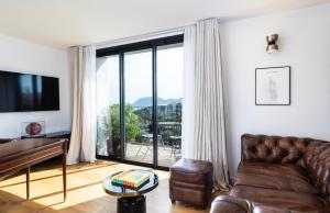 a living room with a couch and a large window at Penthouse Les Oliviers in Porto-Vecchio