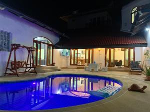 a swimming pool in front of a house at night at Pattaya Beach Pool Villa At Pattaya in Pattaya South