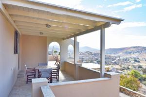 - un balcon d'une maison avec une table et des chaises dans l'établissement Otzia Bay House, 5 minutes walking distance from the beach, à Ioulída