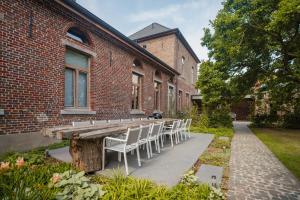 drewniany stół i krzesła przed ceglanym budynkiem w obiekcie Sint-Jacobshoeve 2 w mieście Oudenaarde