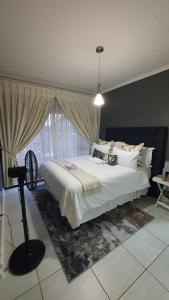 a bedroom with a large white bed and a window at URlyfstyle Cottage Near Mall of Africa in Midrand