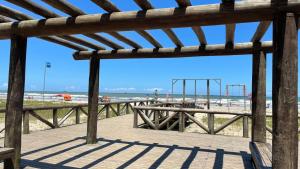 a view of the beach from a wooden boardwalk at Apartamento 1 quadra do mar in Pontal do Paraná