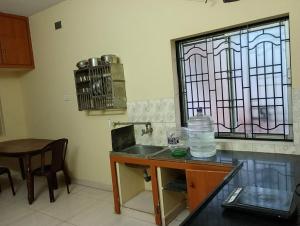 cocina con fregadero y vidriera en Ahobila Delux Homes, en Tiruchchirāppalli