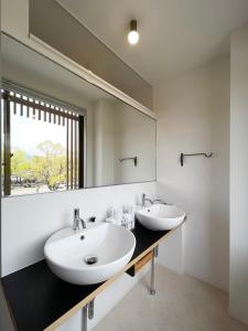 a bathroom with two sinks and a large mirror at bHOTEL Kaniwasou 201 2BR Apt, Near Itsukushima Shrine, For 12 Ppl in Hatsukaichi
