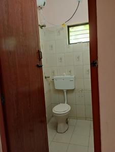 ein kleines Bad mit einem WC und einem Fenster in der Unterkunft Ahobila Delux Homes in Tiruchchirāppalli