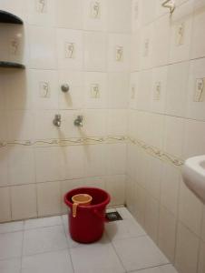 a bathroom with a bucket in the corner of a shower at Ahobila Delux Homes in Tiruchchirāppalli
