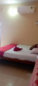 Bett in einem Zimmer mit rotem Hemd drauf in der Unterkunft Ahobila Delux Homes in Tiruchchirāppalli