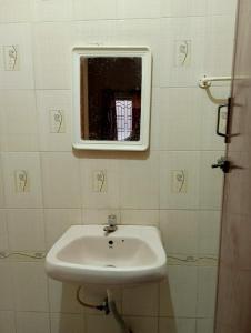 a bathroom with a sink and a mirror at Ahobila Delux Homes in Tiruchchirāppalli