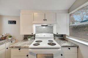 een keuken met een witte kachel en witte kasten bij Tampa Delight Modern 2 Bedroom Retreat in Tampa