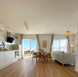 una cucina e un soggiorno con tavolo e divano di Sun Waves Beach Apartment a Portimão