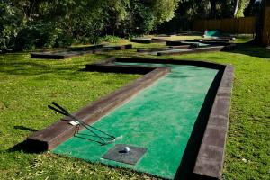 a pool with a clock in the grass at Oudtshoorn Inn Hotel in Oudtshoorn
