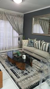 a living room with a couch and a coffee table at URlyfstyle Cottage @ Kikuyu waterfall in Midrand
