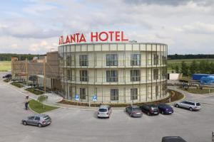 a hotel with cars parked in a parking lot at Hotel Atlanta in Stare Jeżewo