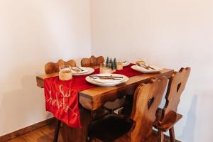 a dining room table with a red table cloth on it at Căsuța cu tihnă in Porumbacu de Sus +41 photos