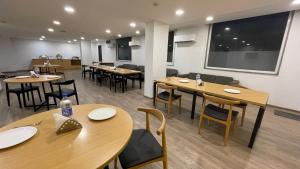 une salle à manger avec des tables et des chaises en bois dans l'établissement Saltstayz Sector 39- Near Rajiv Chowk & Sohna Road, à Gurgaon