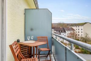 una mesa y sillas en un balcón con vistas en Amalfi A02 - 2 Zi für 4P - Balkon, smart TV, Boxspringbett, en Kaiserslautern