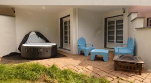 a patio with two blue chairs and a tub at Domaine Moulin Blanc - Gîte Hermine in Meslan