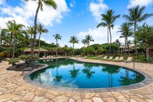 una piscina en un complejo con palmeras en Mauna Lani Fairways 801, en Waikoloa