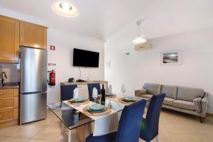 a kitchen and living room with a table and a refrigerator at Casa Mar-a-vila in Olhão