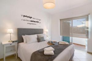 a bedroom with a bed and a window with words on the wall at Casa Mar-a-vila in Olhão