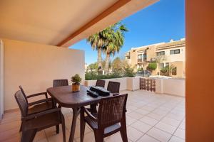a patio with a wooden table and chairs on a patio at Apartamento Villanueva Golf in Puerto Real