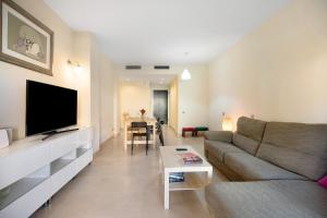 - un salon avec un canapé et une table dans l'établissement Apartamento Villanueva Golf, à Puerto Real
