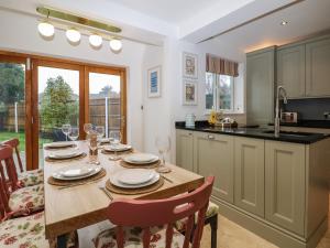 uma cozinha e sala de jantar com uma mesa de madeira e cadeiras em Primrose Place em Worthing