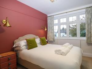 um quarto com uma cama branca e uma parede vermelha em Primrose Place em Worthing