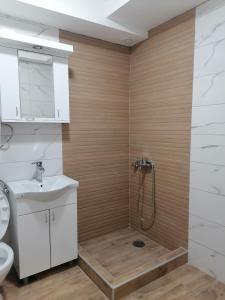 een badkamer met een douche, een toilet en een wastafel bij Apartman Ena in Kraljevo