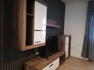 - un centre de divertissement en bois avec une télévision en haut dans l'établissement Apartman Ena, à Kraljevo