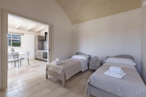 a bedroom with two beds and a dining room at Villa Angi by Perle di Puglia in San Vito dei Normanni