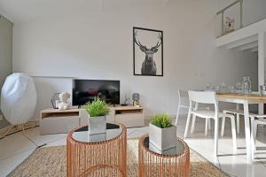 un soggiorno con sedie, tavolo e TV di LE NOE - AC CLiM - Wi-Fi ad Avignone