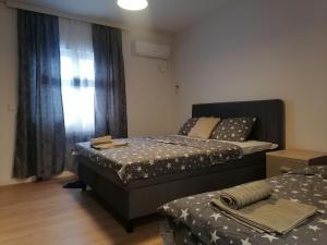 a bedroom with two beds and a window at Apartman Ena in Kraljevo