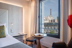 a hotel room with a bed and a view of the eiffel tower at Le Parisis - Paris Tour Eiffel in Paris