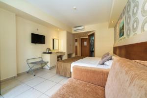 a hotel room with two beds and a desk at Montebello Resort Hotel - All Inclusive in Oludeniz