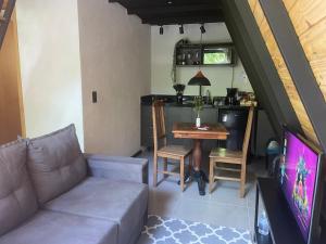 a living room with a couch and a table at Chalés das Palmeiras in Itaipava