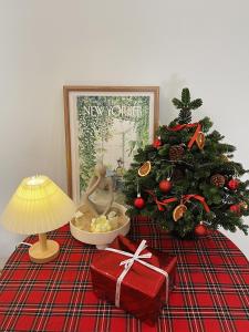 a table with a christmas tree and a present and a lamp at 1.Hôme in Hanoi