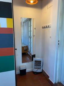 um quarto com um corredor com um espelho e um quarto com uma cama em 3260HOSTEL em Concepción del Uruguay