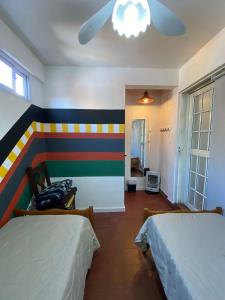 a bedroom with two beds and a colorful wall at 3260HOSTEL in Concepción del Uruguay