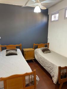 a bedroom with two beds and a blue wall at 3260HOSTEL in Concepción del Uruguay