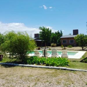 un grupo de sillas sentadas junto a una piscina en Cabañas Hilario en Los Reartes