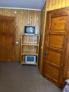 a room with a small television and a door at Калина in Dragobrat