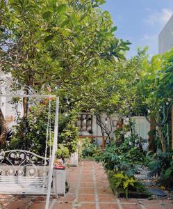 a garden with a white bench and trees at 1.Hôme in Hanoi