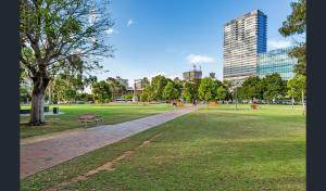 un parco con panchina, albero e edifici di Hi 5 star Adelaide City Luxury Oasis a Adelaide